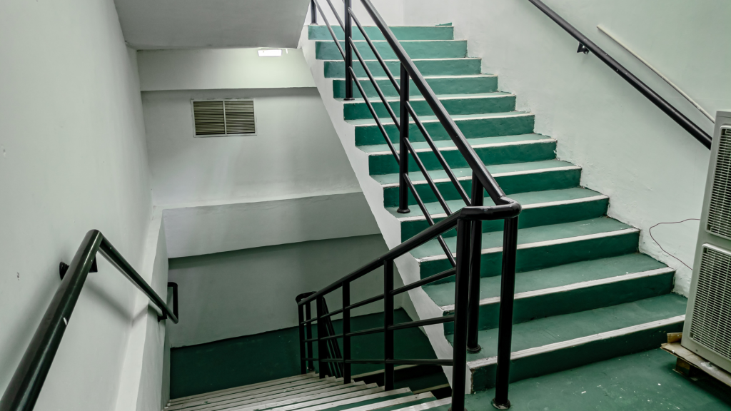 green staircase with black railings in a public building