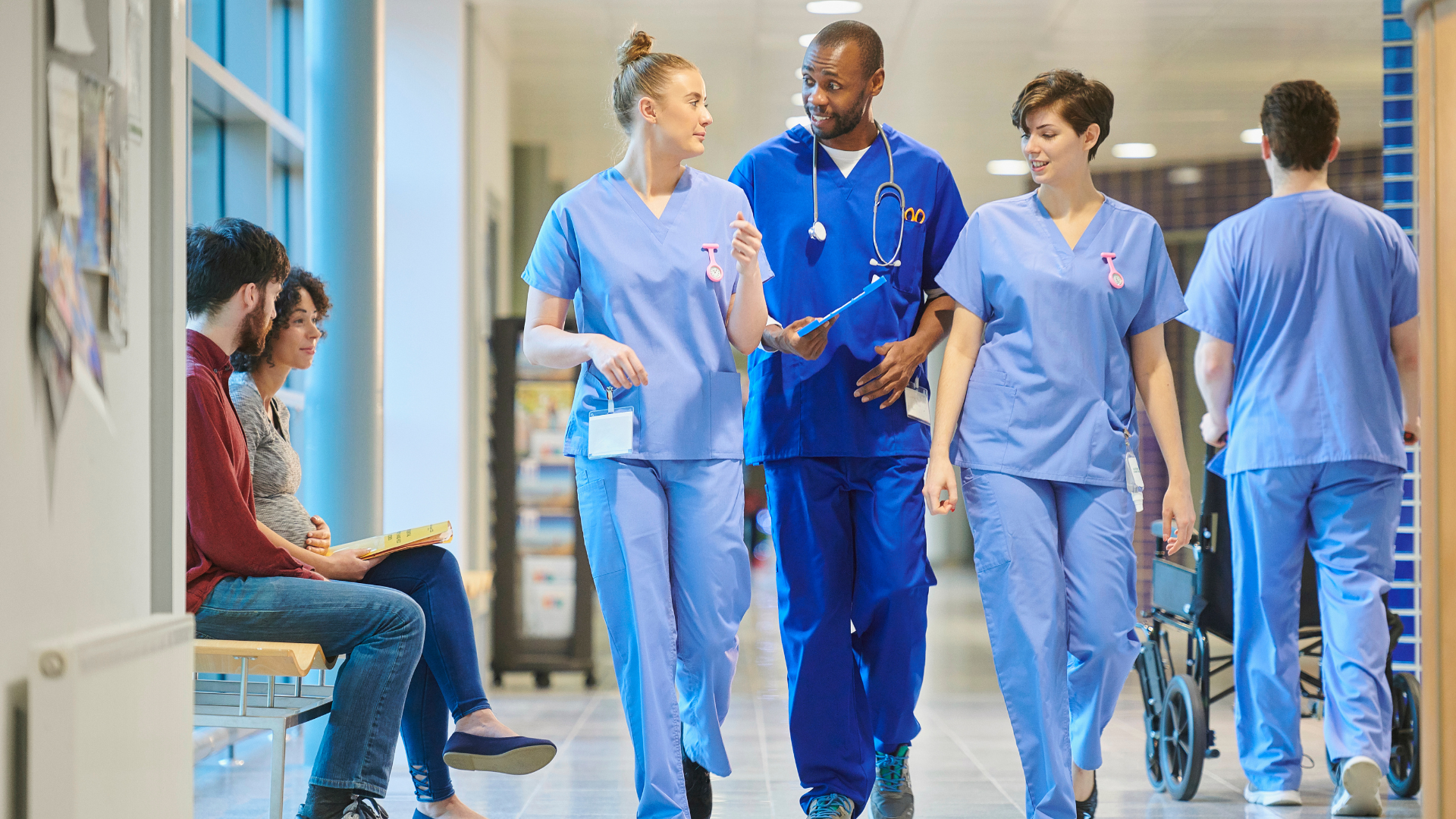nurses and doctors talking in a hospital corridor